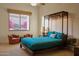 Comfortable bedroom with a unique bedframe, bright window, and access to an outdoor area with lush vegetation at 12711 N 117Th St, Scottsdale, AZ 85259