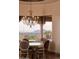 Dining room with scenic views and an elegant chandelier above a glass table with seating at 12711 N 117Th St, Scottsdale, AZ 85259
