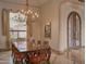 Elegant dining room featuring a decorative chandelier, large window, and ornate wood table with seating for six at 12711 N 117Th St, Scottsdale, AZ 85259