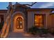 Elegant entryway with arched stone detailing and custom wrought iron door at 12711 N 117Th St, Scottsdale, AZ 85259
