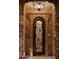Elegant entryway featuring a stone archway and an ornate iron gate at 12711 N 117Th St, Scottsdale, AZ 85259