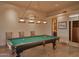 Recreational game room with a billiard table, custom lighting, adjacent seating area, and convenient hallway access at 12711 N 117Th St, Scottsdale, AZ 85259