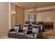 Home theater with comfortable leather recliners, projector, and a window with garden view, perfect for movie nights at 12711 N 117Th St, Scottsdale, AZ 85259