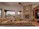 Cozy living room with a stone fireplace, comfortable seating, large windows, and mountain views at 12711 N 117Th St, Scottsdale, AZ 85259