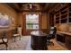 Executive office with custom wood trim, coffered ceilings, built-in shelves, a large window, and an elegant desk at 12711 N 117Th St, Scottsdale, AZ 85259