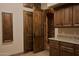 This butler's pantry features custom cabinets with granite counters that adjoins a beautiful brick archway at 12711 N 117Th St, Scottsdale, AZ 85259