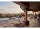 Covered patio with stone pillars overlooks a pool, spa, garden, and distant mountains at 12711 N 117Th St, Scottsdale, AZ 85259