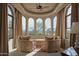Bright sitting area with arched windows showcasing mountain views, ceiling fan, and comfortable seating at 12711 N 117Th St, Scottsdale, AZ 85259