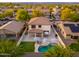 Backyard aerial view with a pool, umbrellas and lush landscaping at 14095 W Larkspur Dr, Surprise, AZ 85379