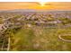 An aerial view of a soccer field, community, and mountains at sunset at 14095 W Larkspur Dr, Surprise, AZ 85379