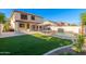 Expansive backyard boasts a pool, patio with picnic table, lush artificial turf, and desert landscaping at 14095 W Larkspur Dr, Surprise, AZ 85379