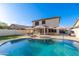 Spacious backyard with private pool, umbrellas, lounge chairs, and a covered patio, perfect for outdoor living at 14095 W Larkspur Dr, Surprise, AZ 85379