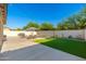 Wide backyard shows a pool with seating, patio space, green lawn and desert landscaping at 14095 W Larkspur Dr, Surprise, AZ 85379