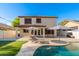 Beautiful backyard features a private pool, patio, tanning lounges, and synthetic grass for easy maintenance at 14095 W Larkspur Dr, Surprise, AZ 85379