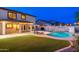 Spacious backyard offering a swimming pool, patio area, and manicured lawn at 14095 W Larkspur Dr, Surprise, AZ 85379