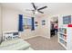 Well-lit bedroom featuring carpet, a window with curtains, a ceiling fan, and a closet at 14095 W Larkspur Dr, Surprise, AZ 85379