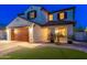 Charming home exterior featuring a two-car garage, manicured lawn, and covered porch at 14095 W Larkspur Dr, Surprise, AZ 85379