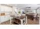 Bright kitchen with kitchen island, stainless appliances, and white cabinets that opens to the living room at 14095 W Larkspur Dr, Surprise, AZ 85379