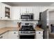 Bright kitchen features stainless appliances, granite countertops, and white cabinets at 14095 W Larkspur Dr, Surprise, AZ 85379