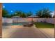 Inviting backyard with a sparkling pool, lounge chairs, umbrellas and string lights at 14095 W Larkspur Dr, Surprise, AZ 85379