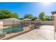 Backyard pool is surrounded by a safety fence and features patio with umbrellas, perfect for outdoor relaxation at 14095 W Larkspur Dr, Surprise, AZ 85379