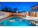 Backyard oasis featuring a large pool, manicured lawn, and ambient string lighting at 14095 W Larkspur Dr, Surprise, AZ 85379