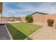A well maintained backyard with a healthy lawn, patio dining set, and decorative landscaping at 14166 W Valentine St, Surprise, AZ 85379
