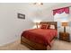 Cozy bedroom featuring a wooden sleigh bed with red bedding and matching nightstands at 14166 W Valentine St, Surprise, AZ 85379