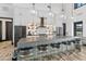 Modern kitchen features stylish island with bar seating, stainless steel appliances, and beautiful pendant lighting at 14166 W Valentine St, Surprise, AZ 85379