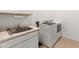Functional laundry room features a sink, countertop, and modern washer and dryer set at 14166 W Valentine St, Surprise, AZ 85379