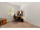 Bright office space with a desk and chair set up, with a window overlooking the front yard at 14166 W Valentine St, Surprise, AZ 85379