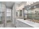 Elegant bathroom with dual sinks, quartz countertops, and a tiled walk-in shower at 16945 W Vernon Ave, Goodyear, AZ 85395
