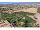 Scenic aerial of a well-maintained golf course with players, lush greenery, and clear blue skies at 16945 W Vernon Ave, Goodyear, AZ 85395