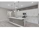 Bright, modern kitchen with white cabinetry, stainless steel appliances, a large island, and stylish pendant lighting at 16945 W Vernon Ave, Goodyear, AZ 85395