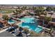 Community pool area with a large pool, lounge chairs, palm trees, and several parked cars at 16945 W Vernon Ave, Goodyear, AZ 85395