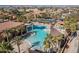 Aerial view of an expansive pool area with lounging spots surrounded by lush greenery and palm trees at 16945 W Vernon Ave, Goodyear, AZ 85395