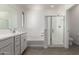 Modern bathroom featuring a tub, glass-enclosed shower, and a vanity with a large mirror at 16996 W Fetlock Trl, Surprise, AZ 85387