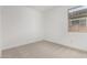 A bright bedroom offers a serene space with plush carpeting and natural light from a window at 16996 W Fetlock Trl, Surprise, AZ 85387