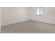 Bright bedroom with neutral carpet, white walls, and a window offering natural light at 16996 W Fetlock Trl, Surprise, AZ 85387