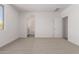 Well-lit bedroom with carpet, white walls, and a bathroom entrance, offering a serene atmosphere at 16996 W Fetlock Trl, Surprise, AZ 85387