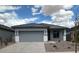 Charming single-story home featuring a gray color scheme, a two-car garage, and a well-maintained front yard at 16996 W Fetlock Trl, Surprise, AZ 85387