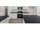 Modern kitchen featuring white cabinets, stainless steel appliances, dark countertops, and tile backsplash at 16996 W Fetlock Trl, Surprise, AZ 85387