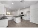 Modern kitchen with island, white cabinets, and dark countertops at 16996 W Fetlock Trl, Surprise, AZ 85387