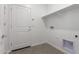 A functional laundry room is equipped with tile floors, shelving, and utility connections at 16996 W Fetlock Trl, Surprise, AZ 85387