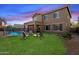 Spacious backyard features a covered patio, pool with safety fence, a fire pit, and raised garden beds at 18585 E Ryan Rd, Queen Creek, AZ 85142