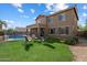 Expansive backyard featuring lush green grass, a sparkling pool, and a cozy outdoor seating area for relaxation at 18585 E Ryan Rd, Queen Creek, AZ 85142
