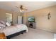 Spacious bedroom with a ceiling fan, television, and carpet flooring at 18585 E Ryan Rd, Queen Creek, AZ 85142