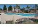 Large community pool with lounge chairs and mature vegetation, perfect for relaxing and enjoying the sunny weather at 18585 E Ryan Rd, Queen Creek, AZ 85142