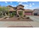 Stunning two-story home showcasing desert landscaping, a spacious three car garage, and a welcoming front entrance at 18585 E Ryan Rd, Queen Creek, AZ 85142