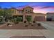 Charming two-story home with a manicured front yard, complemented by an attached two-car garage and a beautiful sunset at 18585 E Ryan Rd, Queen Creek, AZ 85142